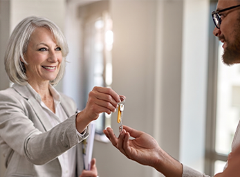 Suzanne Hunn handing keys to a new homeowner